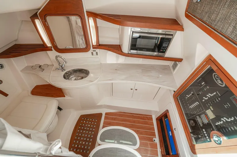 Dos Amigos Yacht Photos Pics 2020 Grady-White Freedom 375 cabin interior with sink, microwave, and control panel.