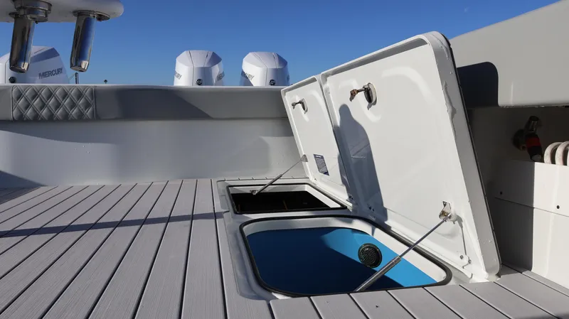  Yacht Photos Pics 2021 Freeman 47 boat deck with open storage compartments and visible engines.