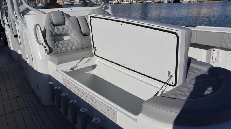  Yacht Photos Pics Open storage compartment on a 2021 Freeman 47 boat, with cushioned seating and rod holders.