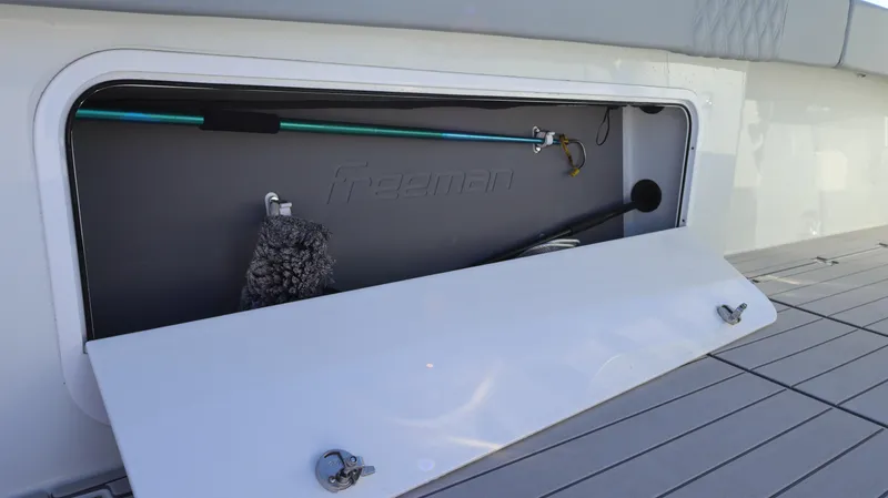  Yacht Photos Pics Storage compartment on a 2021 Freeman 47 boat, featuring cleaning tools and equipment.