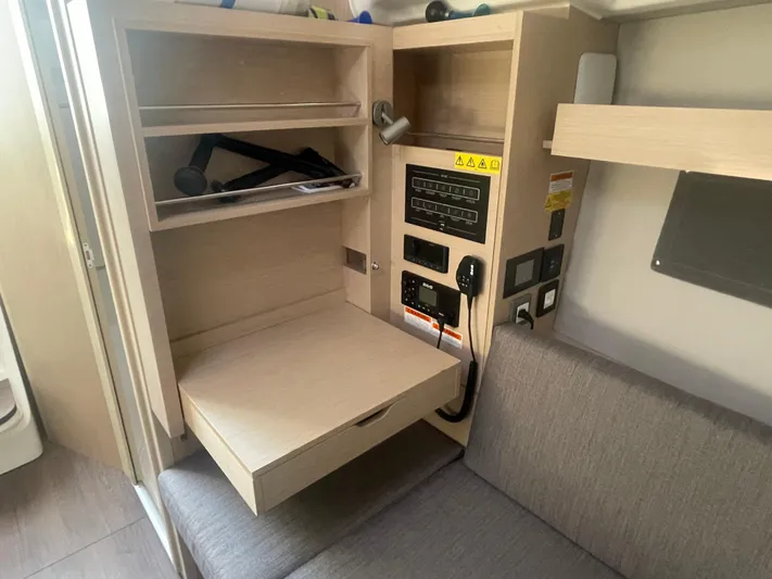 Cutting Edge Yacht Photos Pics Interior of 2023 Beneteau Oceanis 34.1 yacht with control panel and seating area.