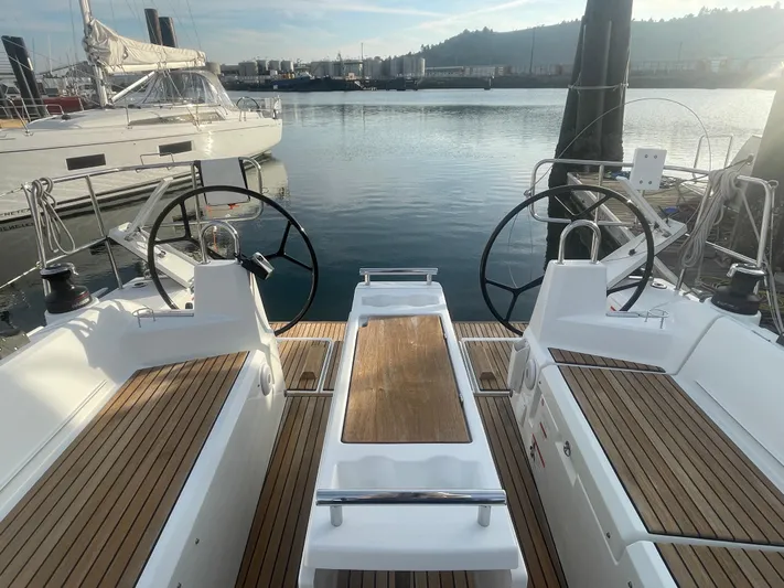 Cutting Edge Yacht Photos Pics 2023 Beneteau Oceanis 34.1 yacht cockpit with dual steering wheels and wooden deck.