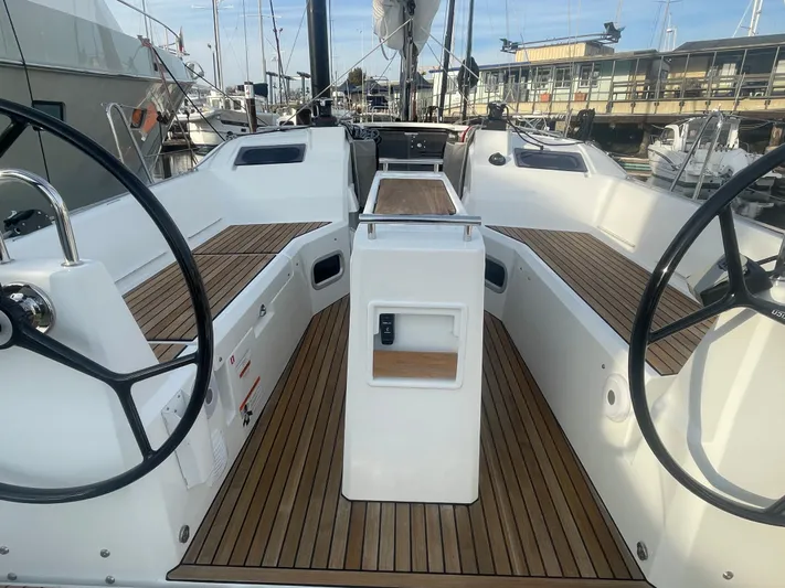 Cutting Edge Yacht Photos Pics 2023 Beneteau Oceanis 34.1 sailboat cockpit with dual steering wheels and teak flooring.