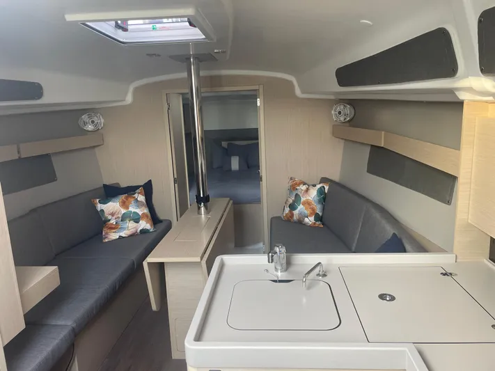 Cutting Edge Yacht Photos Pics 2023 Beneteau Oceanis 34.1 interior with modern seating and compact kitchen area.
