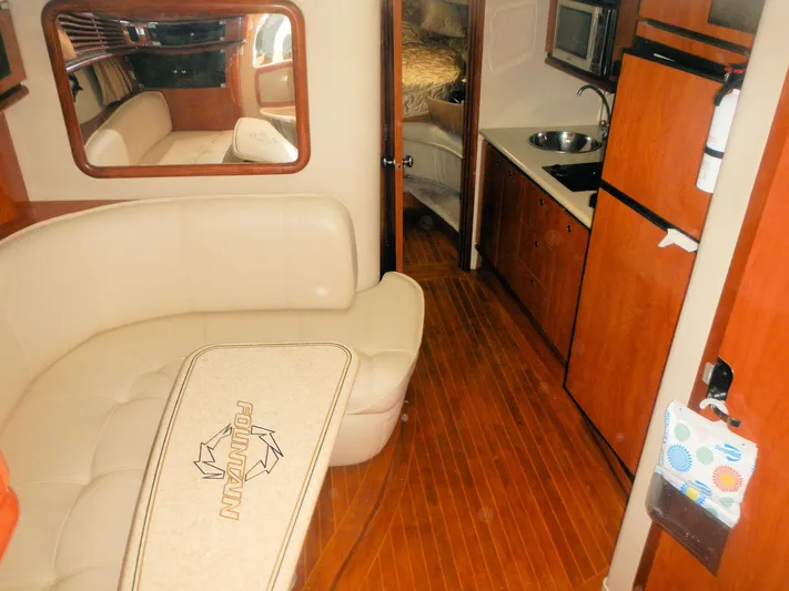  Yacht Photos Pics Interior of 2006 Fountain 48 Express Cruiser with kitchen and seating area.