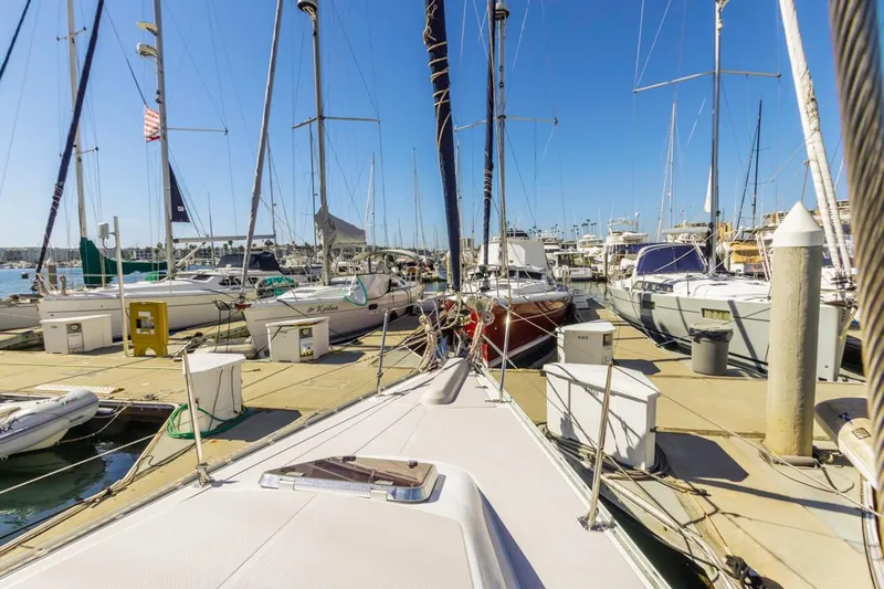 Kia Ora Yacht Photos Pics Catalina 385 sailboat docked in a marina, surrounded by other boats, clear blue sky.