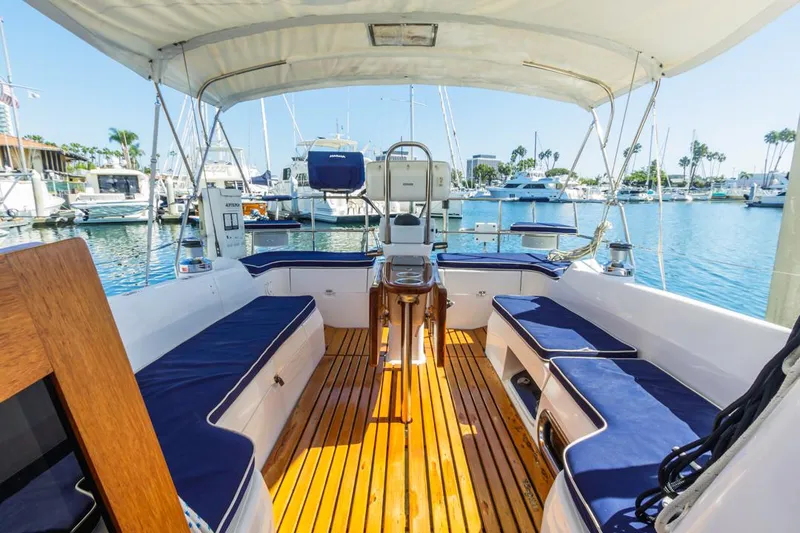 Kia Ora Yacht Photos Pics Catalina 385 sailboat cockpit, 2014 model, with wooden flooring and blue cushioned seating.