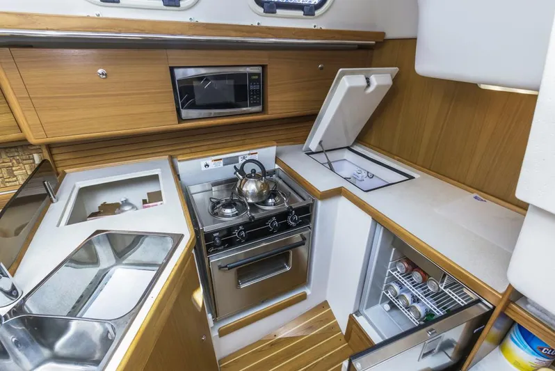 Kia Ora Yacht Photos Pics Catalina 385 yacht kitchen interior with stove, microwave, and fridge, 2014 model.