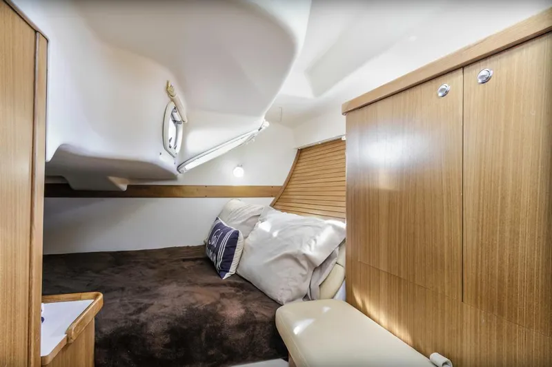 Kia Ora Yacht Photos Pics Cozy cabin interior of 2014 Catalina 385 sailboat with wooden finishes and comfortable bedding.