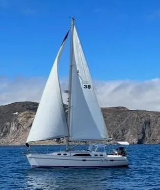 Kia Ora Yacht Photos Pics 2014 Catalina 385 sailboat cruising on open water with scenic rocky coastline.