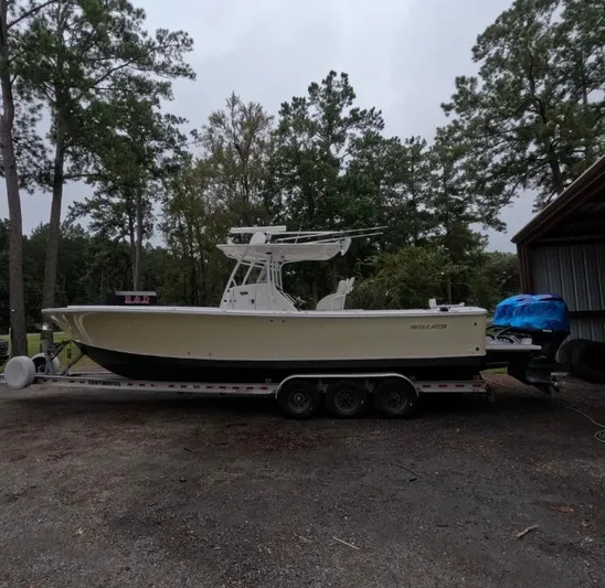  Yacht Photos Pics 2013 Regulator 34 Center Console boat on trailer, surrounded by trees.