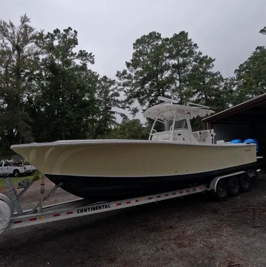  Yacht Photos Pics 2013 Regulator 34 Center Console boat on trailer, surrounded by trees.