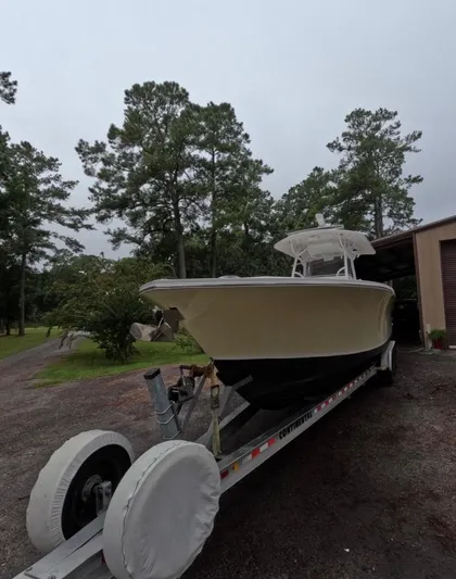  Yacht Photos Pics 2013 Regulator 34 Center Console boat on trailer, surrounded by trees.