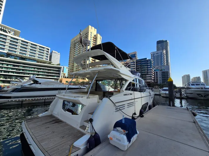  Yacht Photos Pics 2015 Absolute 56 FLY yacht docked in a modern marina with city skyline.