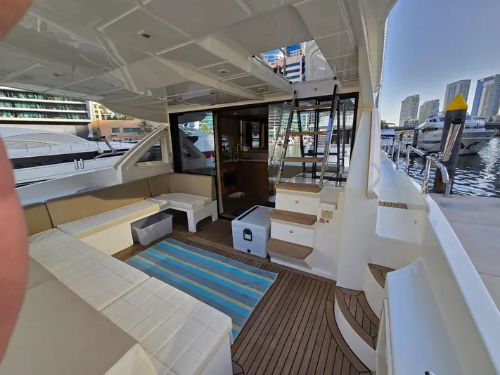  Yacht Photos Pics Luxurious 2015 Absolute 56 FLY yacht interior with seating, wooden flooring, and marina view.