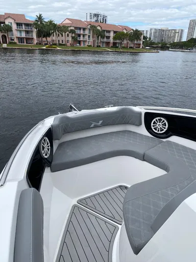  Yacht Photos Pics 2024 NX Boats 280 Xtreme bow with gray seating, on a scenic waterfront.