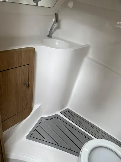  Yacht Photos Pics 2024 NX Boats 280 Xtreme bathroom with sink, toilet, and wooden cabinet.