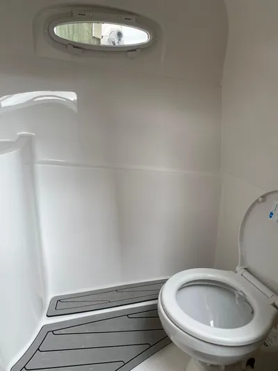  Yacht Photos Pics 2024 NX Boats 280 Xtreme interior bathroom with toilet and window.