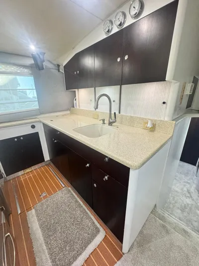  Yacht Photos Pics Modern kitchen in 2000 Ocean Yachts 48, featuring sleek cabinetry and wood flooring.