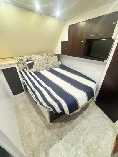  Yacht Photos Pics Cozy bedroom in 2000 Ocean Yachts 48 with striped bedding and modern decor.