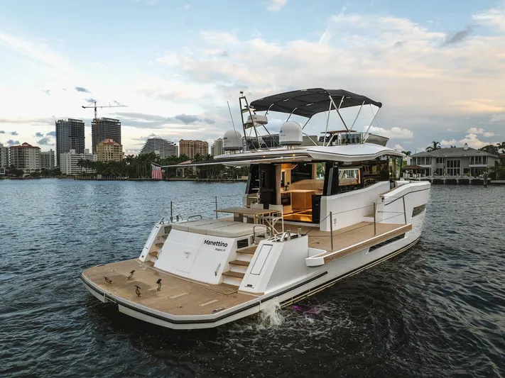 Yacht Photos Pics 2022 Pardo Yachts E60 cruising on a scenic waterfront with city skyline.