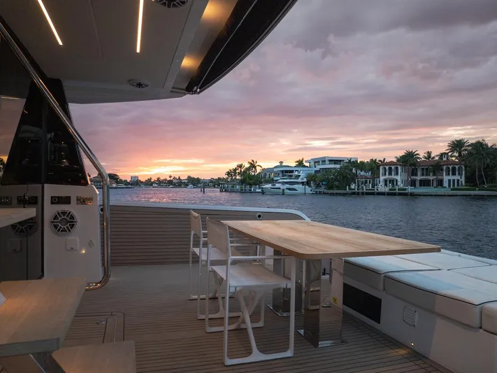  Yacht Photos Pics Luxurious 2022 Pardo Yachts E60 deck at sunset, overlooking serene waterfront homes.