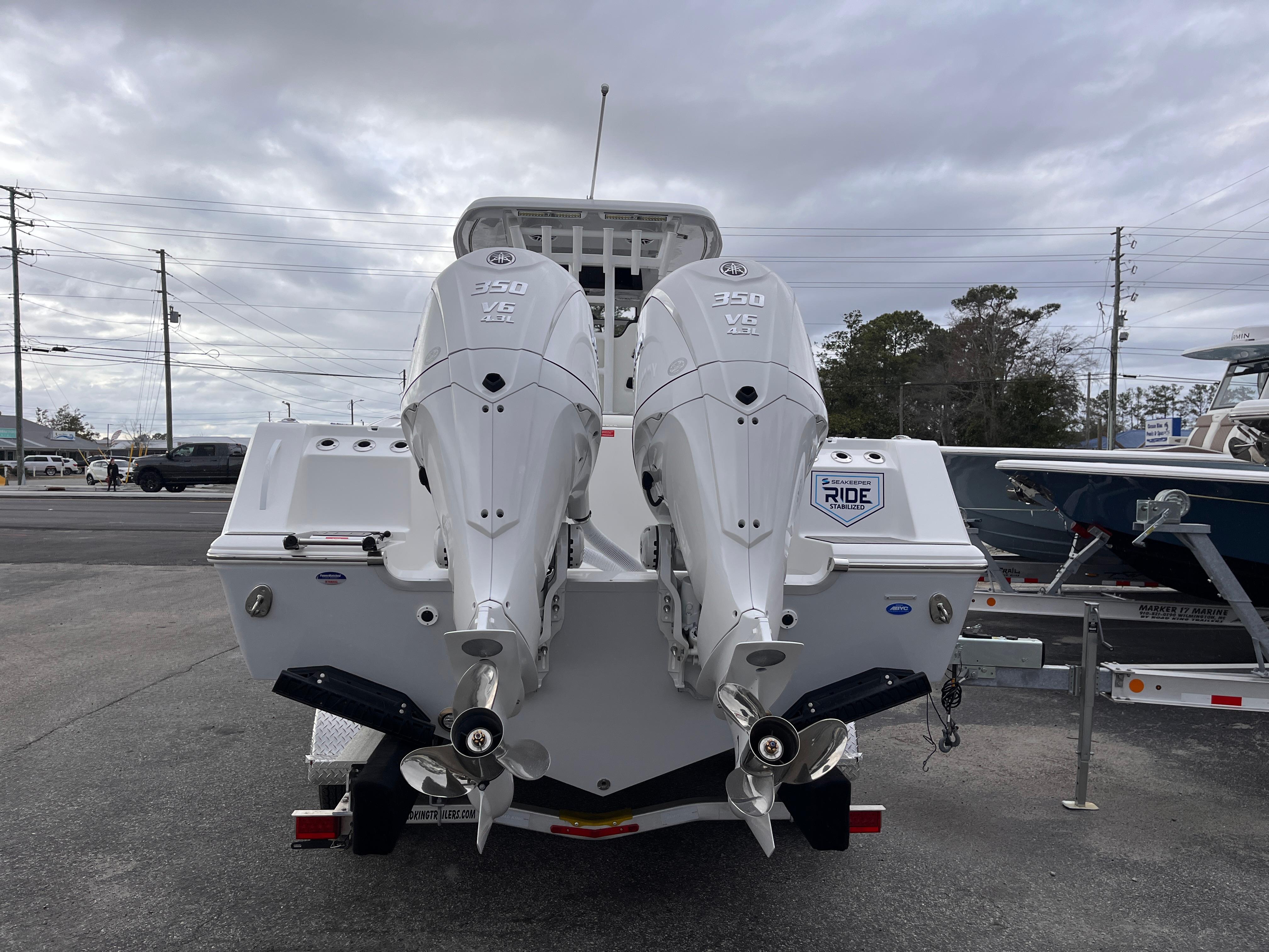 2025 Tidewater 302 CC Adventure boat with dual outboard engines, parked on a trailer.