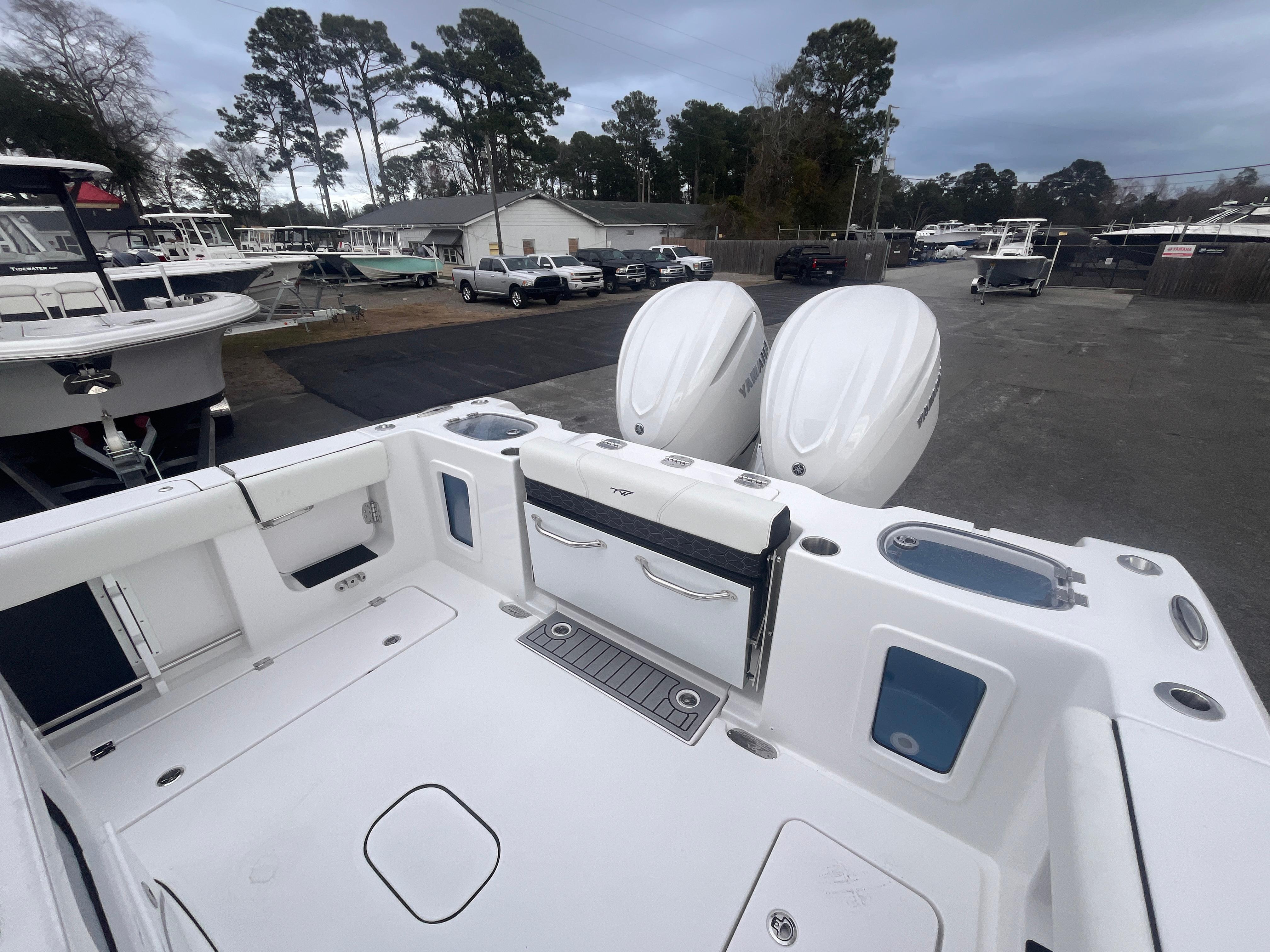 2025 Tidewater 302 CC Adventure boat with dual engines, docked in a marina.