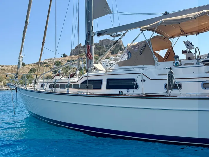  Yacht Photos Pics 2008 Island Packet 465 sailboat anchored in clear blue water, with scenic coastal backdrop.