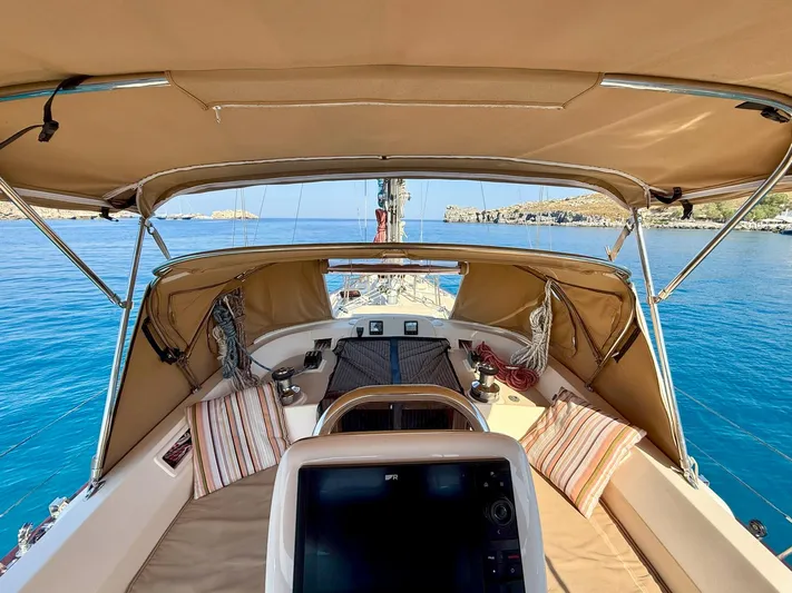  Yacht Photos Pics 2008 Island Packet 465 sailboat cockpit with tan canopy, striped cushions, and ocean view.