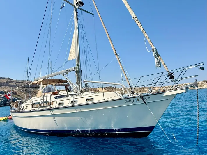  Yacht Photos Pics 2008 Island Packet 465 sailboat anchored in clear blue water, featuring a Canadian flag.