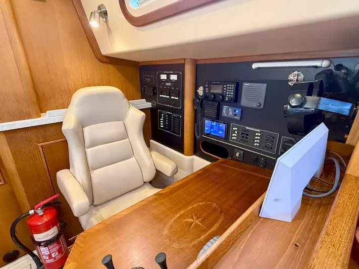  Yacht Photos Pics Navigation station of 2008 Island Packet 465 yacht with control panels and beige chair.