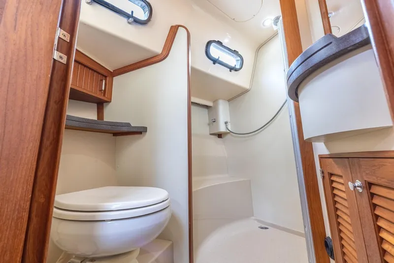  Yacht Photos Pics 2008 Island Packet 465 yacht bathroom with shower, toilet, and wooden cabinetry.