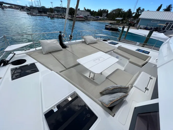  Yacht Photos Pics Luxurious 2020 Bali 4.8 catamaran deck with seating and table, docked by the water.