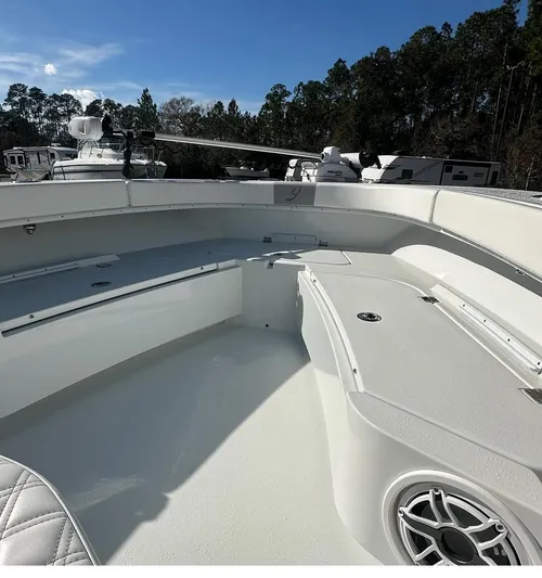  Yacht Photos Pics Bow area of 2023 Young 27 boat, featuring seating and storage, under clear blue sky.