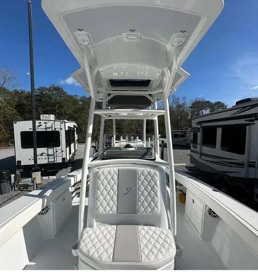  Yacht Photos Pics 2023 Young 27 boat with sleek design, parked near RVs and trees.