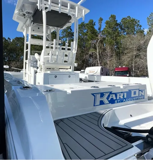  Yacht Photos Pics 2023 Young 27 boat with elevated helm, docked in a wooded area.
