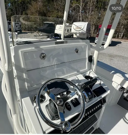  Yacht Photos Pics 2023 Young 27 boat dashboard with steering wheel and controls in a parking area.