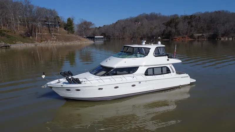  Yacht Photos Pics 2005 Carver 56 Voyager yacht on a calm lake with wooded shoreline.