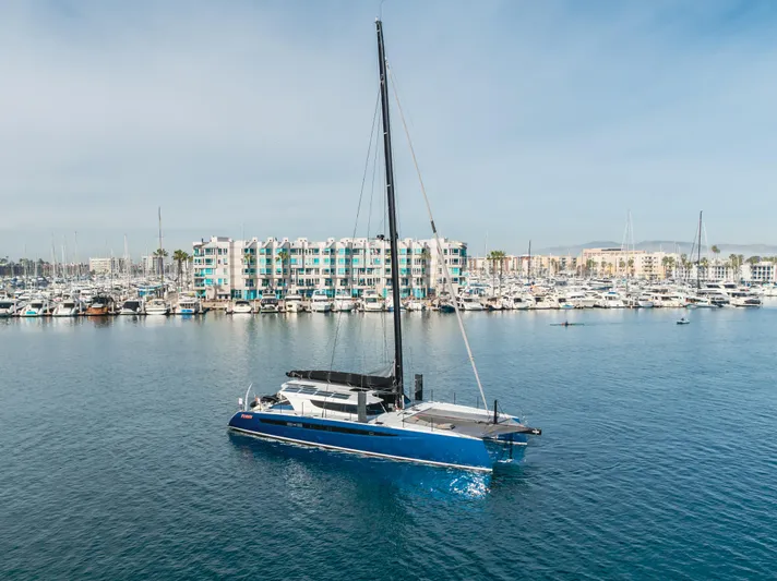 Flash Yacht Photos Pics 2017 HH Catamarans HH66 sailing in marina with waterfront buildings in background.