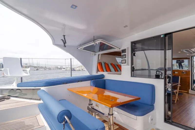 Flash Yacht Photos Pics Luxurious 2017 HH Catamarans HH66 yacht interior with blue seating and wooden table.