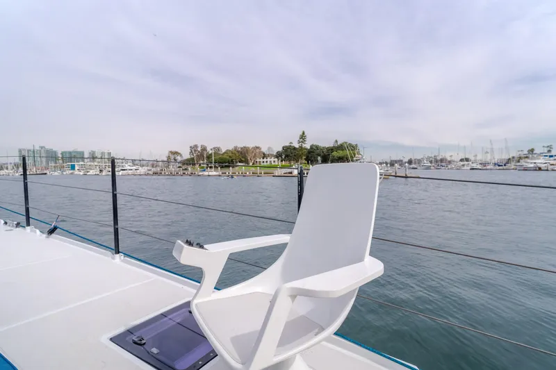 Flash Yacht Photos Pics White chair on deck of 2017 HH Catamarans HH66, overlooking marina and calm waters.