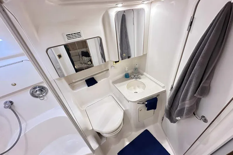  Yacht Photos Pics Bathroom interior of 2000 Sea Ray 410 Sundancer yacht, featuring sink, toilet, and mirror.