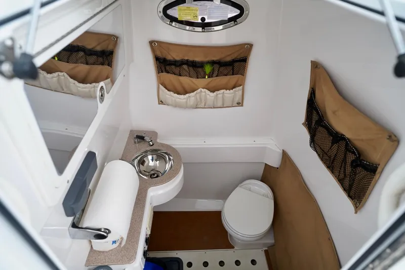  Yacht Photos Pics 2015 Southport 29 FE boat interior with compact bathroom, sink, and storage pockets.