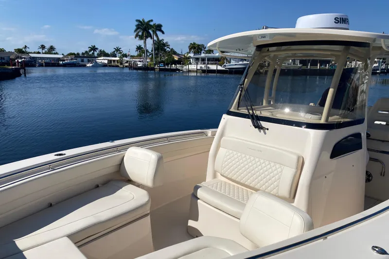  Yacht Photos Pics 2024 Grady-White Canyon 306 boat on calm water, featuring luxurious seating and modern design.