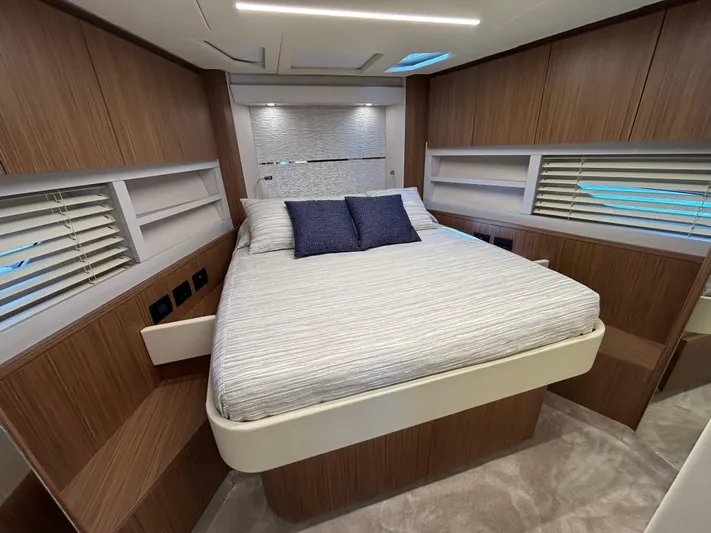  Yacht Photos Pics Luxurious bedroom interior of 2025 Filippetti S55 yacht with modern wood paneling and cozy bedding.