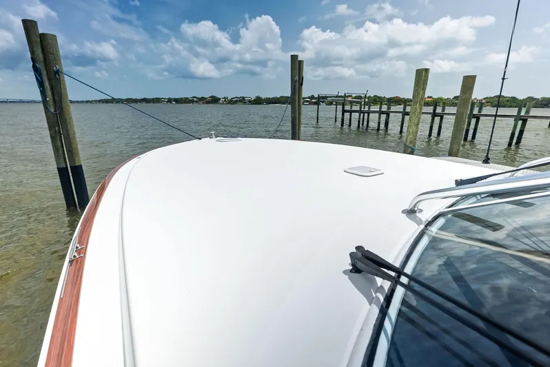 Ohayo Yacht Photos Pics 2010 Viking 52 Open yacht docked by wooden posts under a partly cloudy sky.