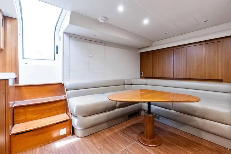 Ohayo Yacht Photos Pics 2010 Viking 52 Open yacht interior with wooden table, beige seating, and stairs.