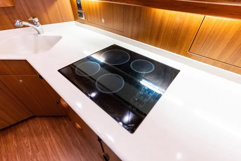 Ohayo Yacht Photos Pics Modern kitchen in 2010 Viking 52 Open yacht with sleek stovetop and wooden cabinetry.