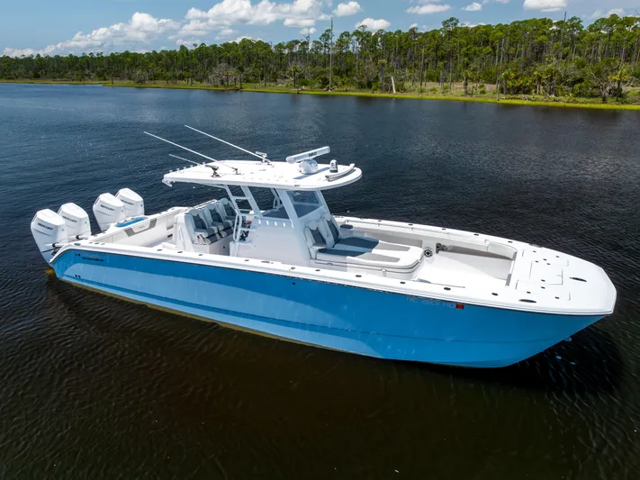  Yacht Photos Pics 2024 Invincible 37 Catamaran in blue, docked on calm water, with four outboard engines.